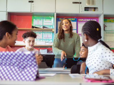 Female teacher inside classroom with junior high students looking at her